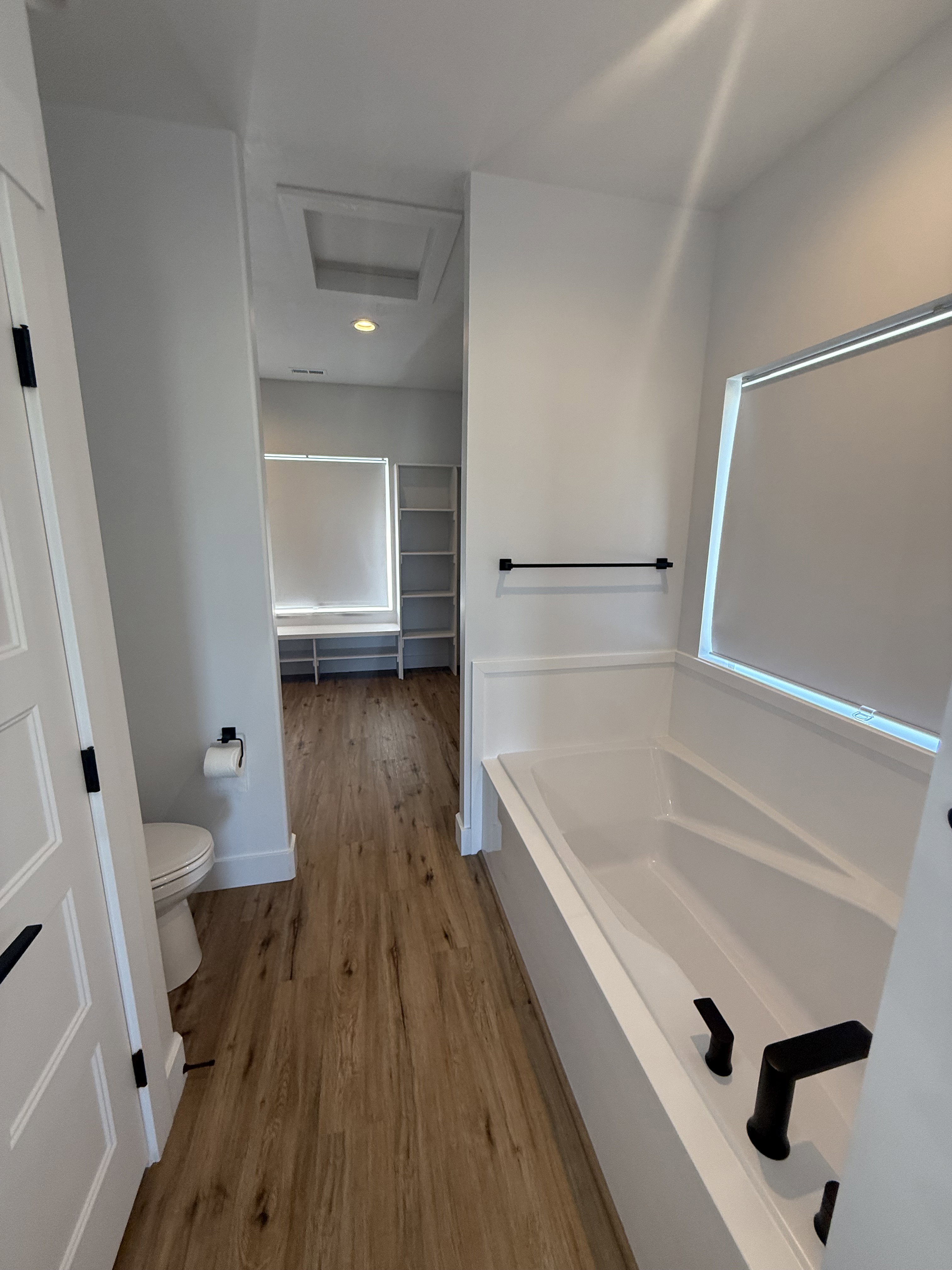 Full bath featuring a bath and light wood-type flooring