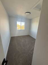 Empty room with dark colored carpet and baseboards