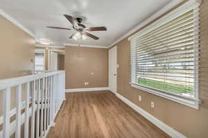 Unfurnished room with ceiling fan, wood finished floors, and ornamental molding