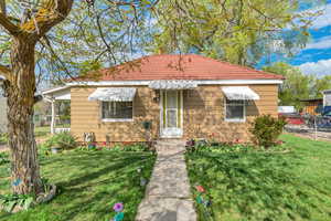 View of front of property with a front lawn and a tiled roof