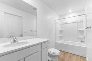 Bathroom with light wood-style floors, vanity, and  shower combination