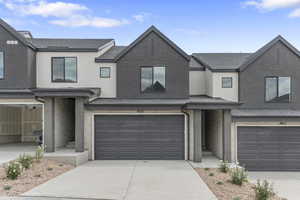 Traditional-style house with stucco siding, an attached garage, concrete driveway, a shingled roof, and stone siding