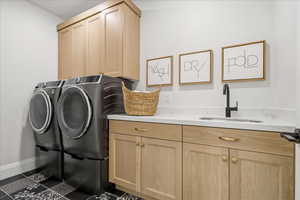 Laundry room featuring cabinet space, tile patterned flooring, and washing machine and clothes dryer.  One of two laundry rooms