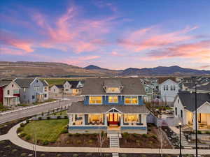 View of front facade featuring covered porch, a residential view, a mountain view, and a shingled roof