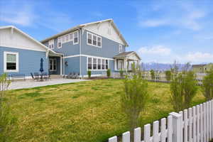 Rear view of property featuring board and batten siding, a mountain view, and a patio