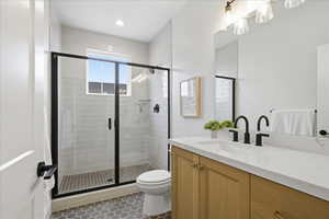 Bathroom featuring vanity, a shower stall, and dark tile patterned flooring