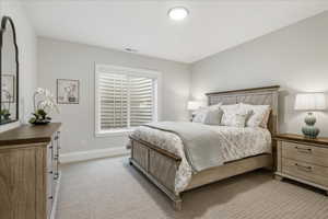 Bedroom featuring light carpet and baseboards