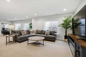 Living area with light carpet, plenty of natural light, and recessed lighting