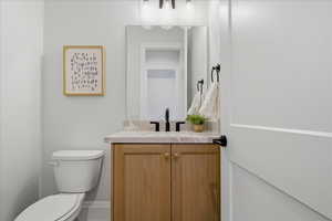Half bath featuring vanity and toilet