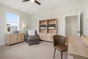 Office with a ceiling fan and light carpet