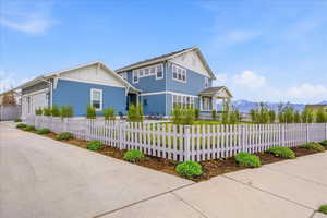 View of front of home featuring board and batten siding, a fenced front yard, and a garage