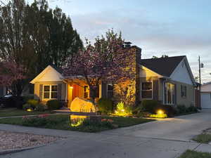 View of front of property with an outbuilding, a chimney, and a garage