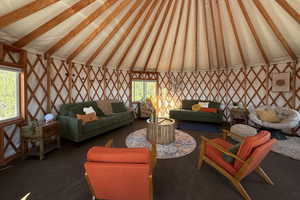 Living area featuring lofted ceiling with beams and carpet flooring