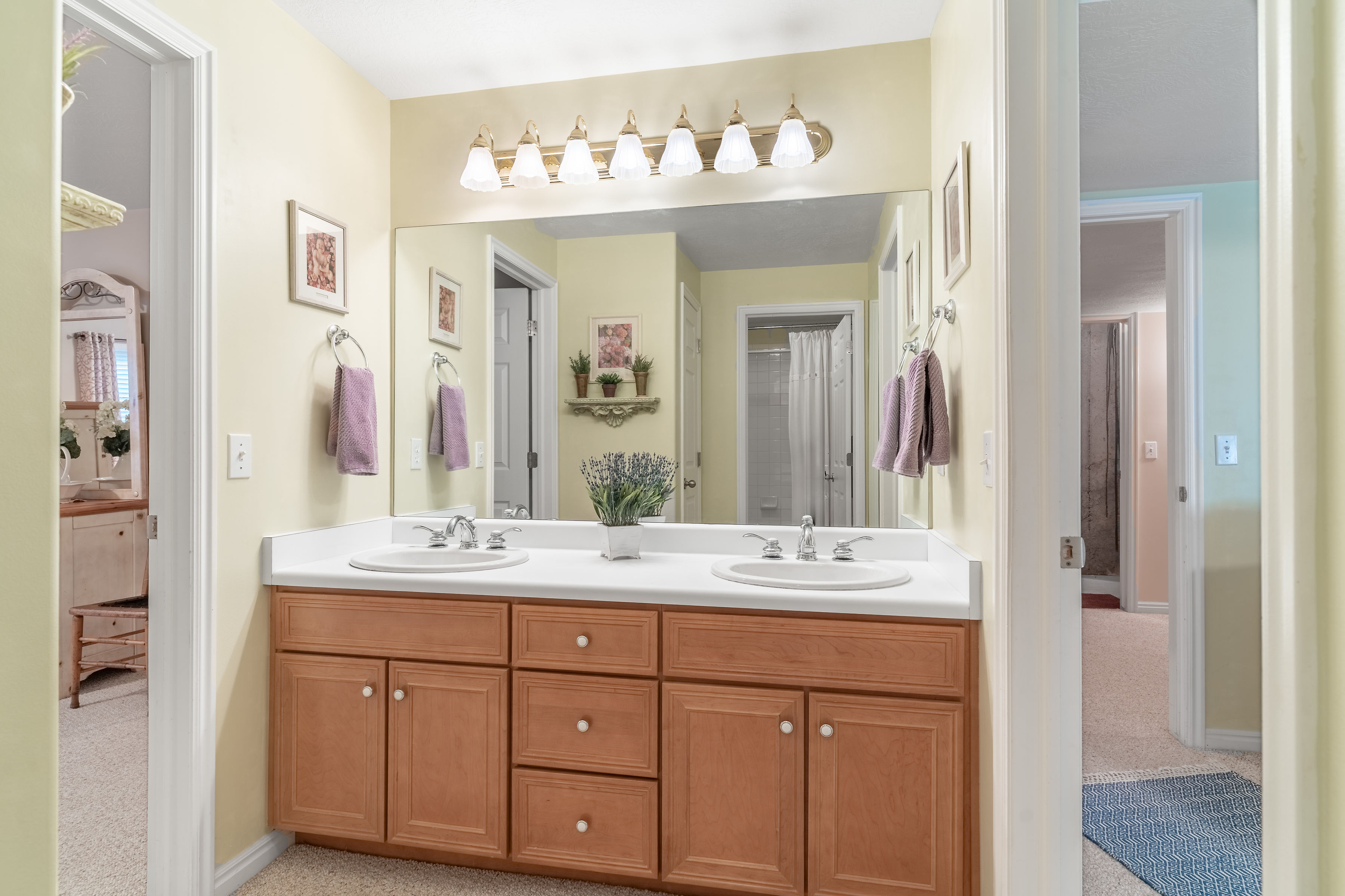 Bathroom featuring double vanity and light carpet