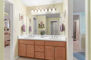 Bathroom featuring double vanity and light carpet