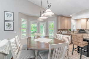 Dining room with vaulted ceiling, light tile patterned flooring, and recessed lighting