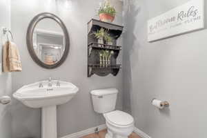 Half bathroom featuring toilet and light tile patterned floors