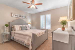Bedroom with a ceiling fan and light carpet