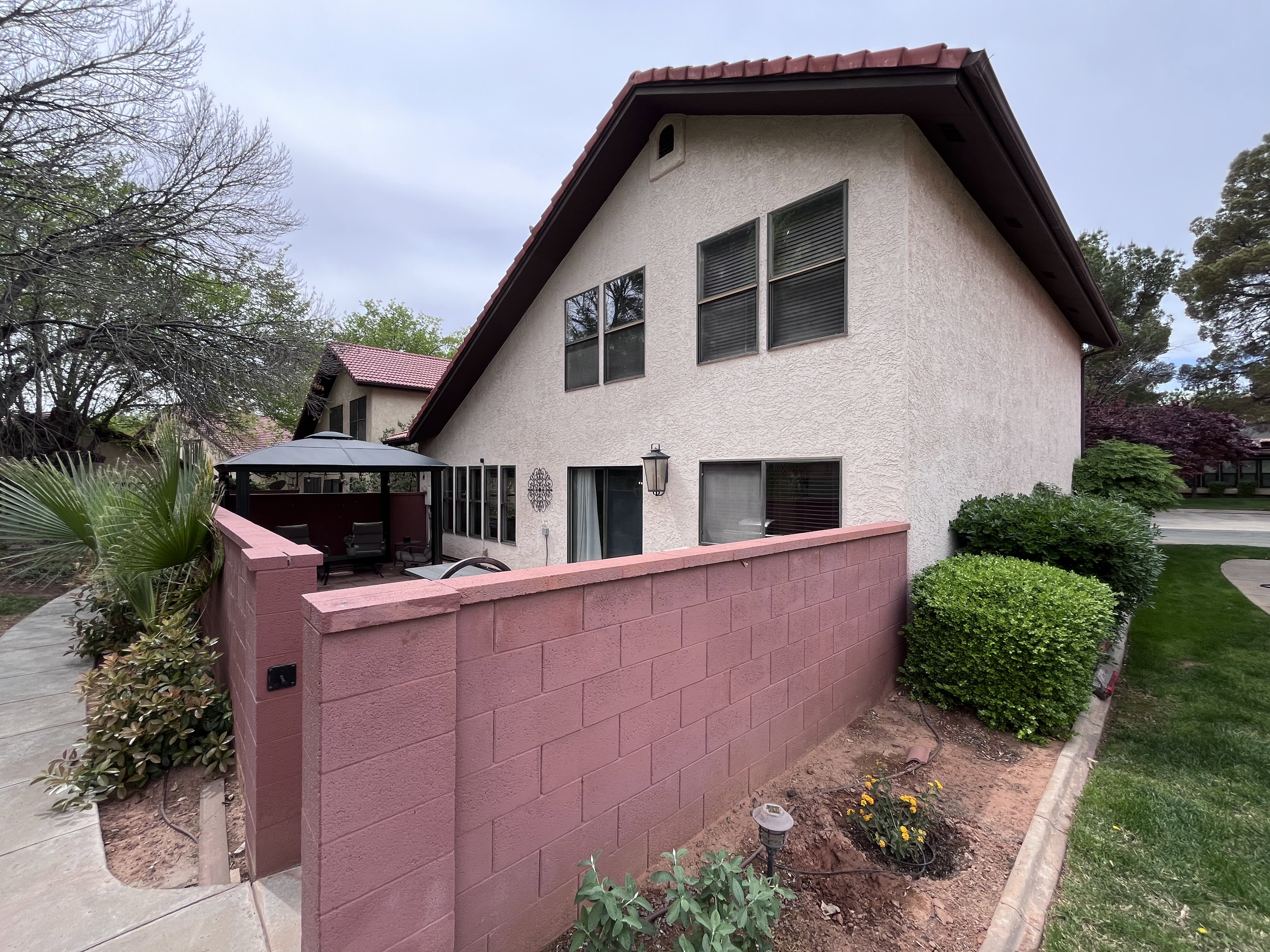 Rear view of house featuring stucco siding and a gazebo