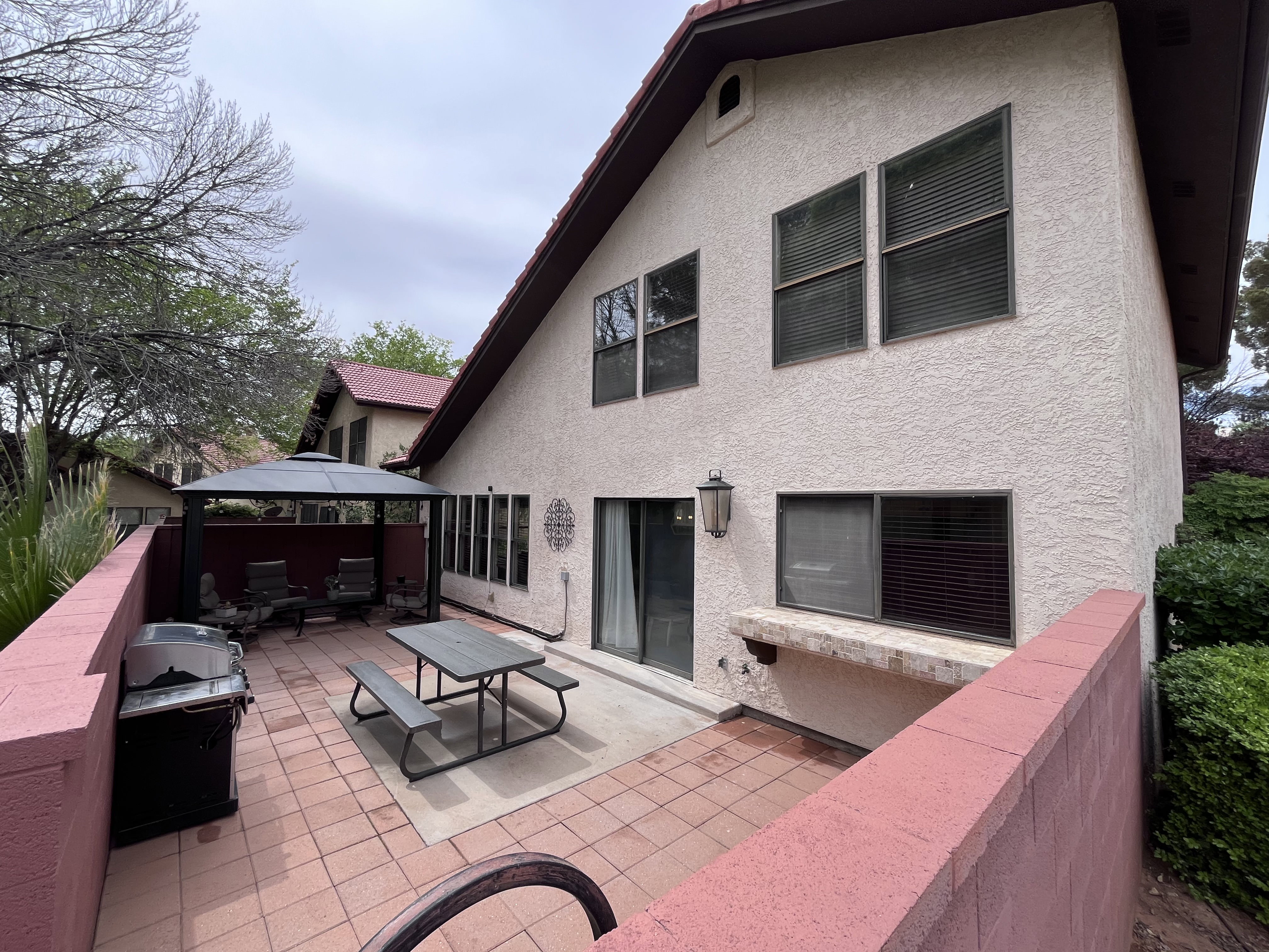 Back of house featuring stucco siding, a gazebo, and a patio area