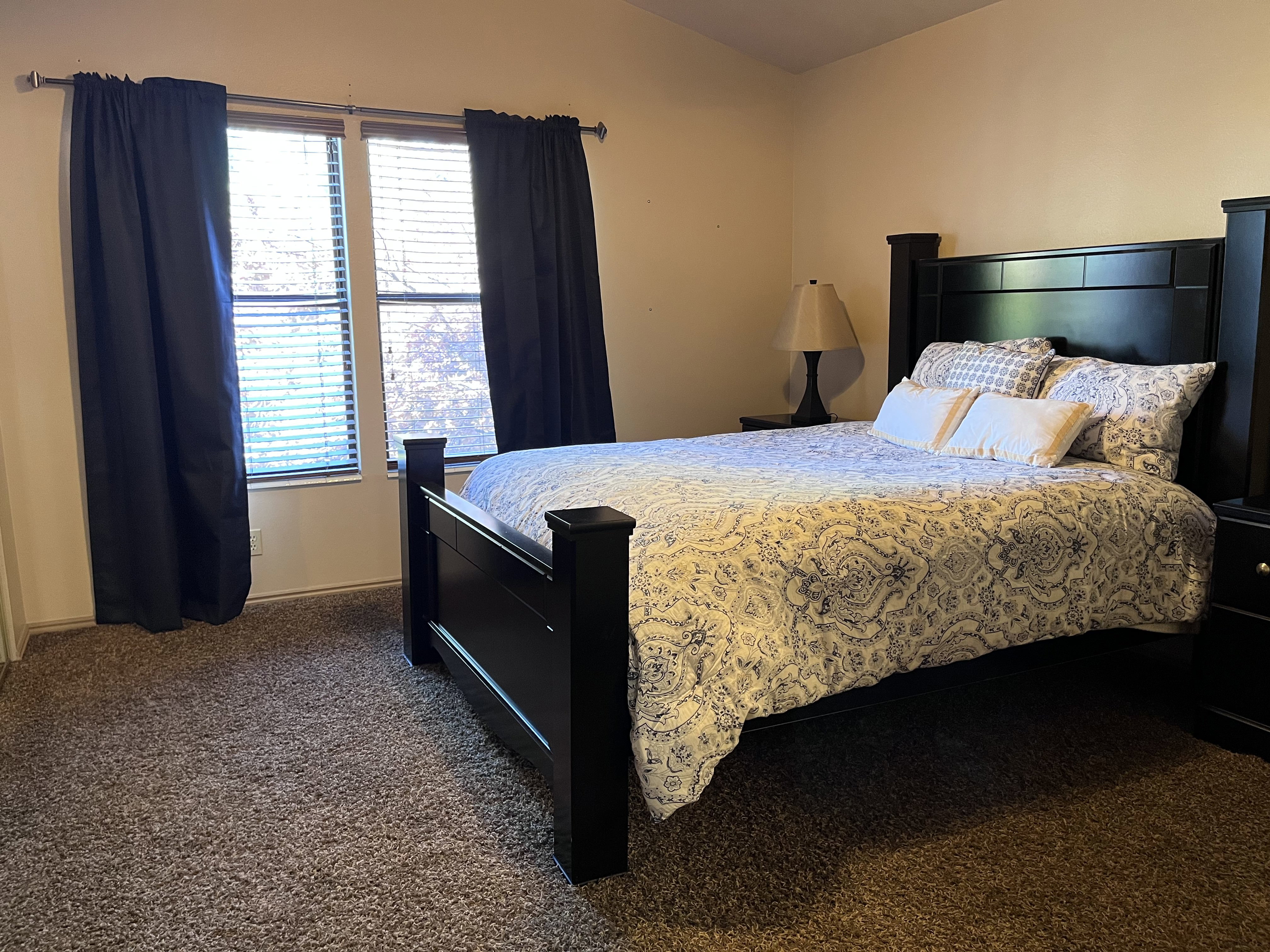 Bedroom with dark colored carpet and baseboards