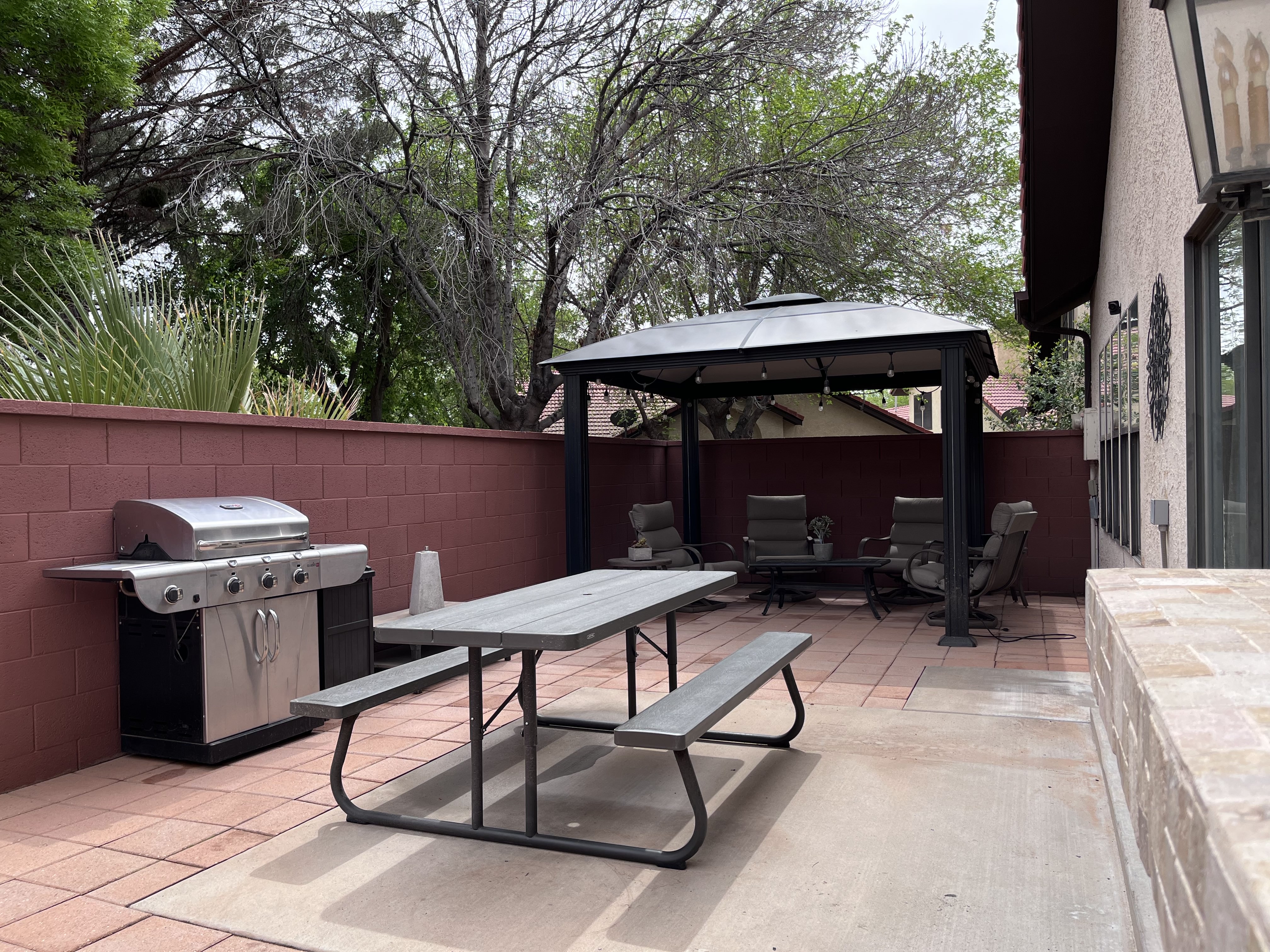 Fenced backyard featuring a gazebo, a patio area, and a grill