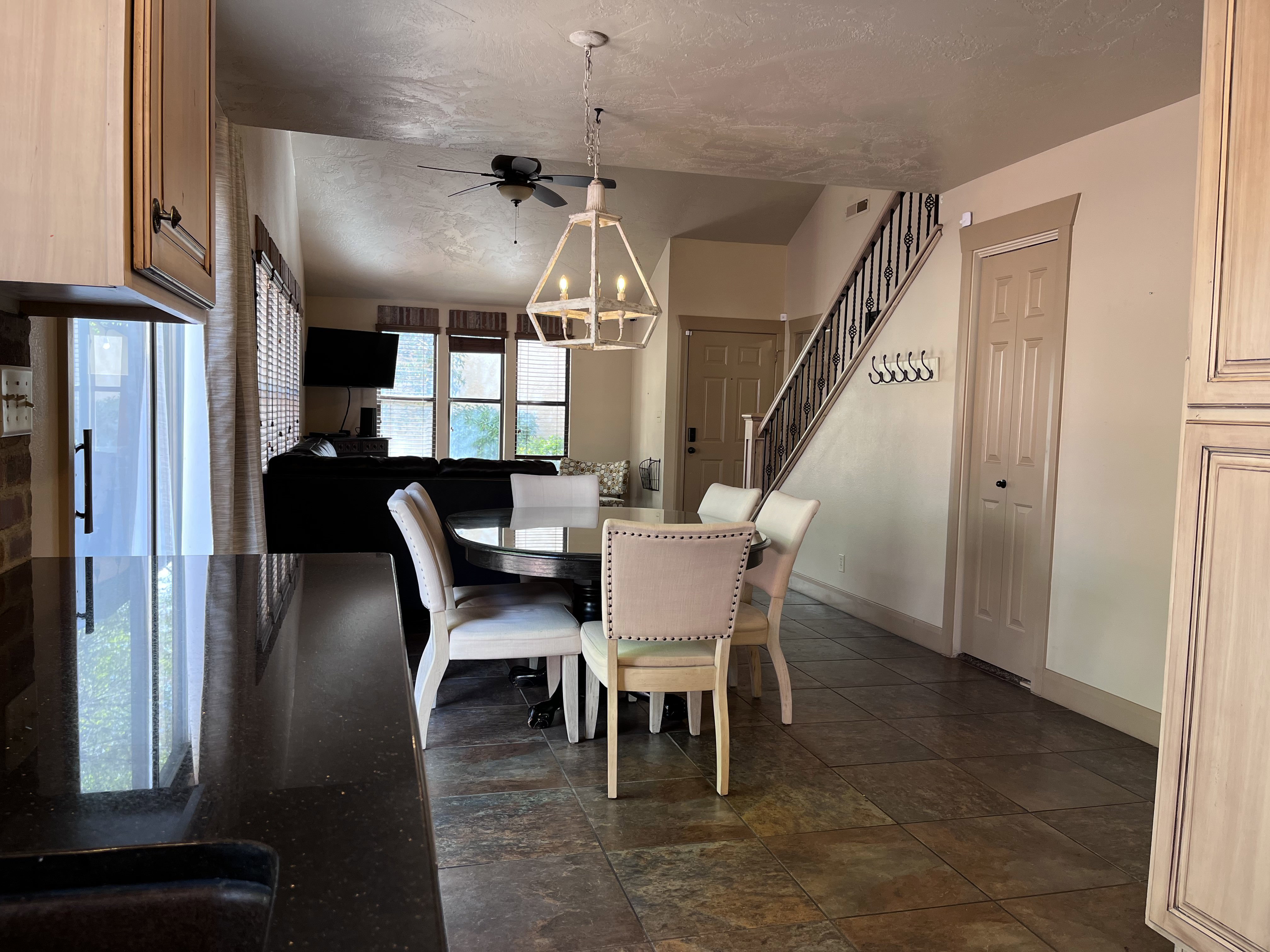 Dining room with dark stone finish flooring, hanging lights, and ceiling fan