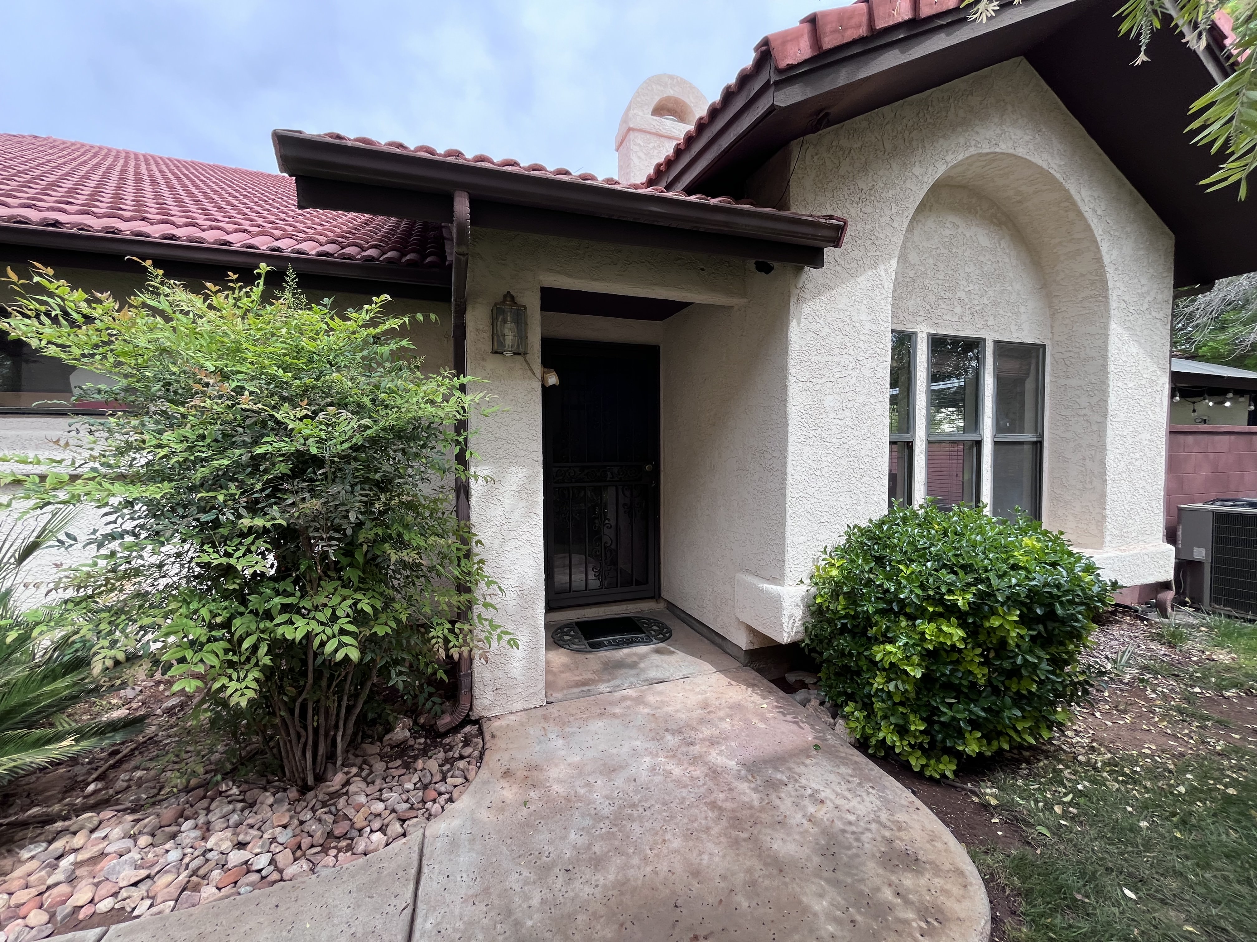 Doorway to property with stucco siding and a tile roof