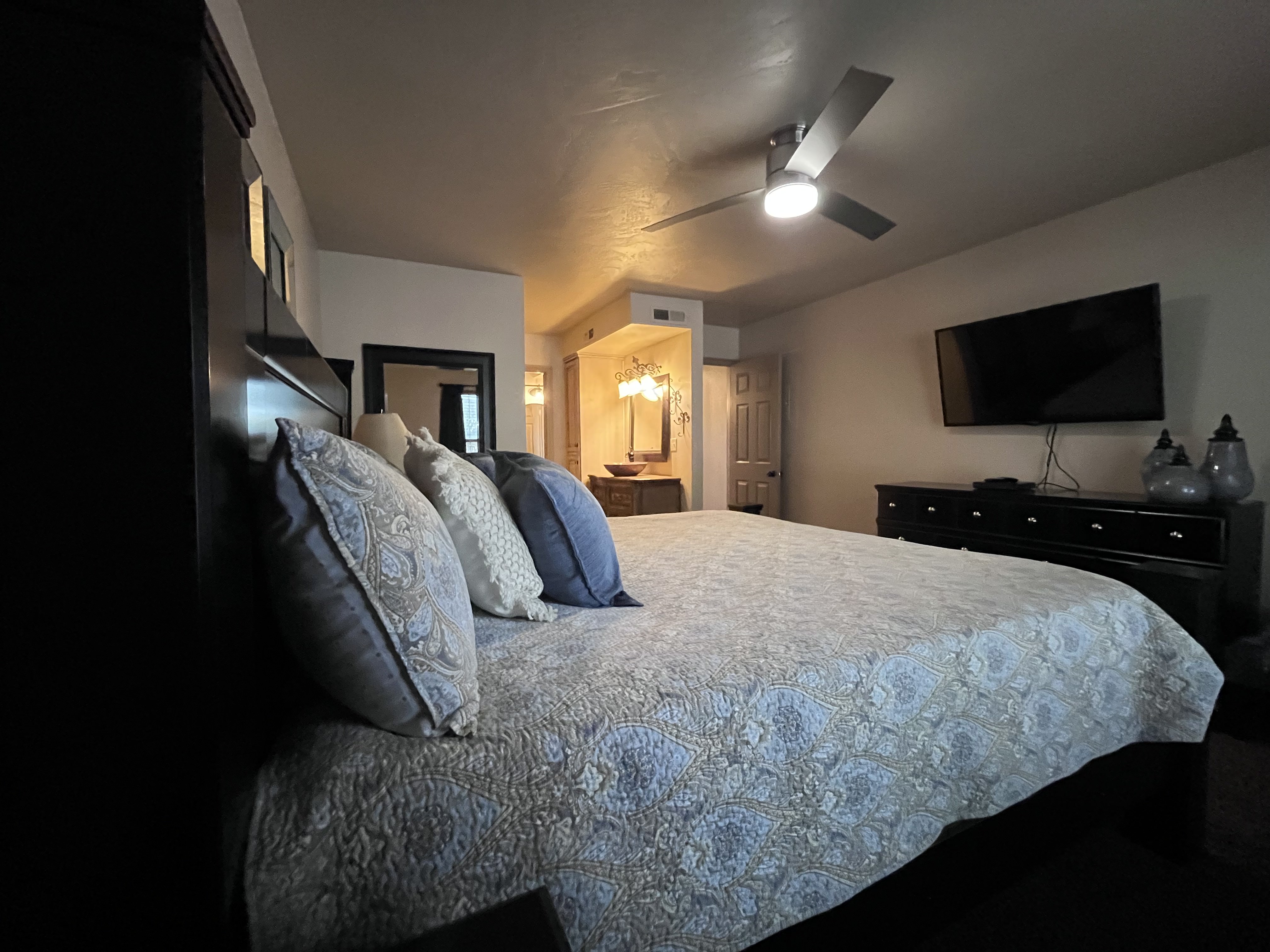 Bedroom featuring ensuite bath and a ceiling fan