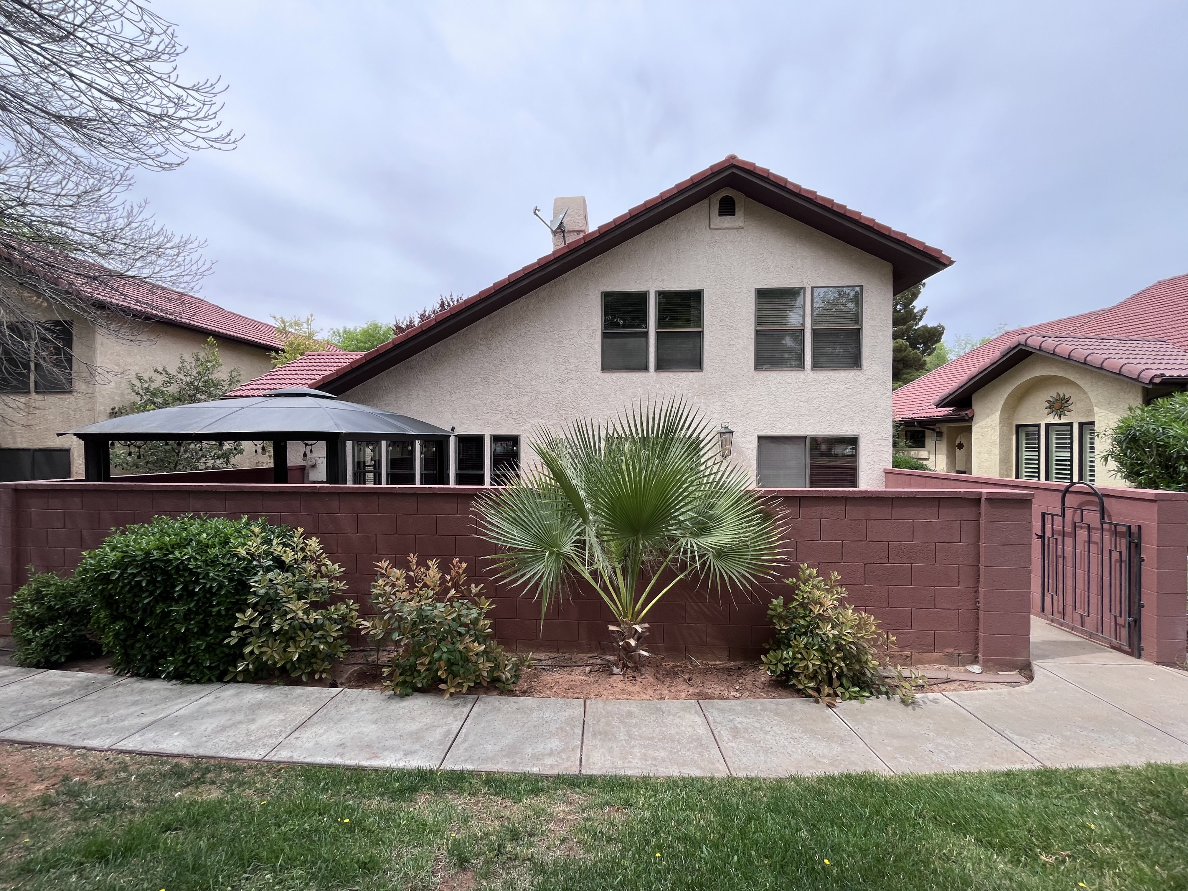 View of front of property featuring stucco siding and a gate