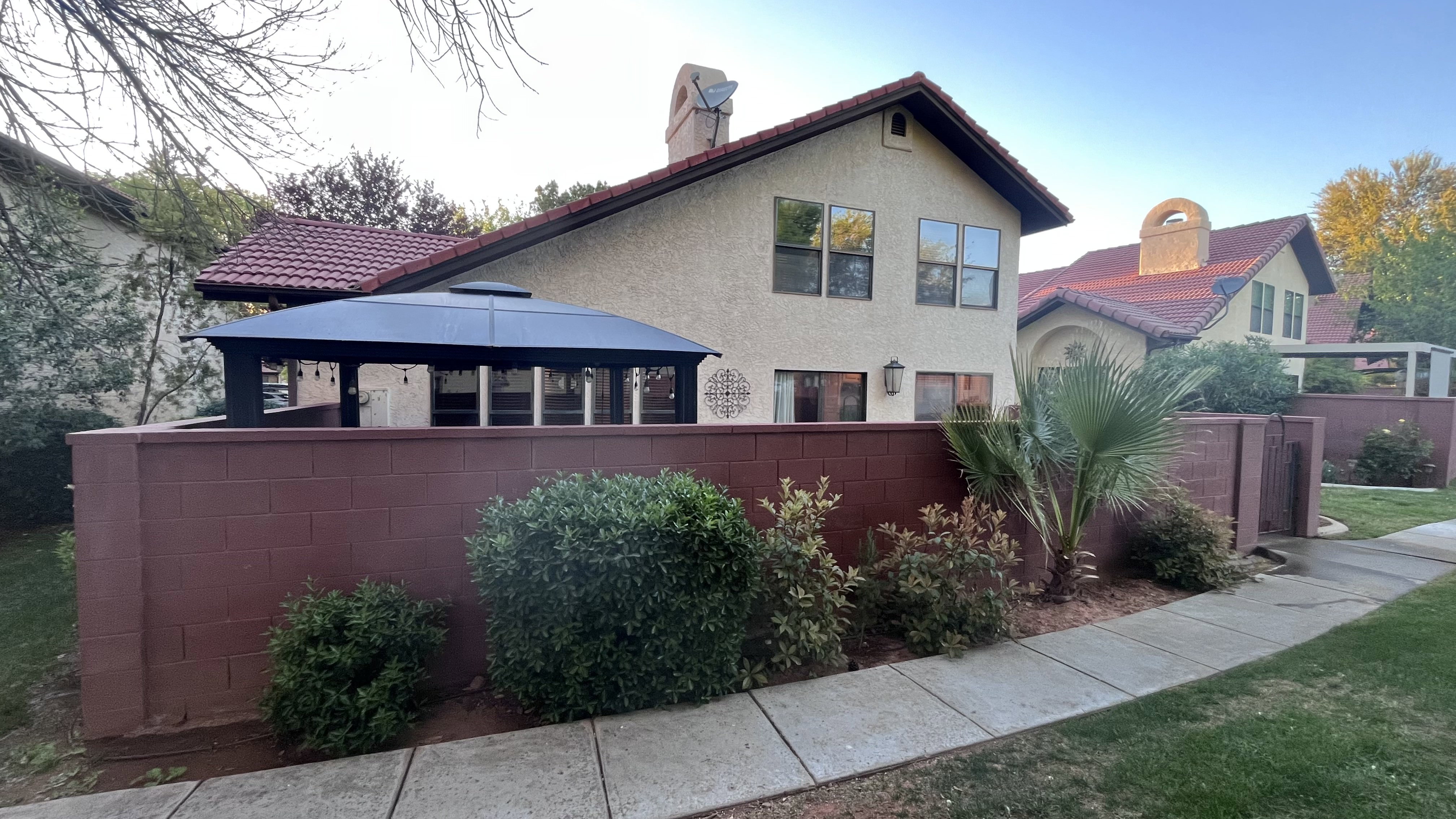Back of property featuring stucco siding, a tiled roof, and a chimney