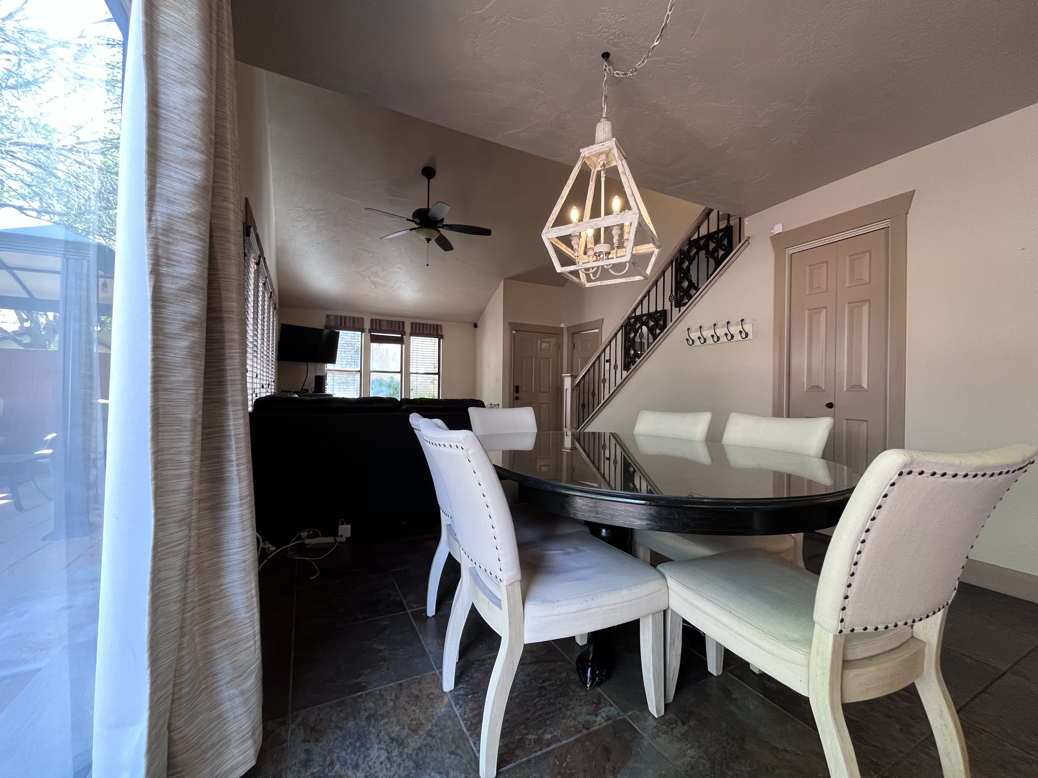 Dining space featuring ceiling fan, hanging lights, and vaulted ceiling
