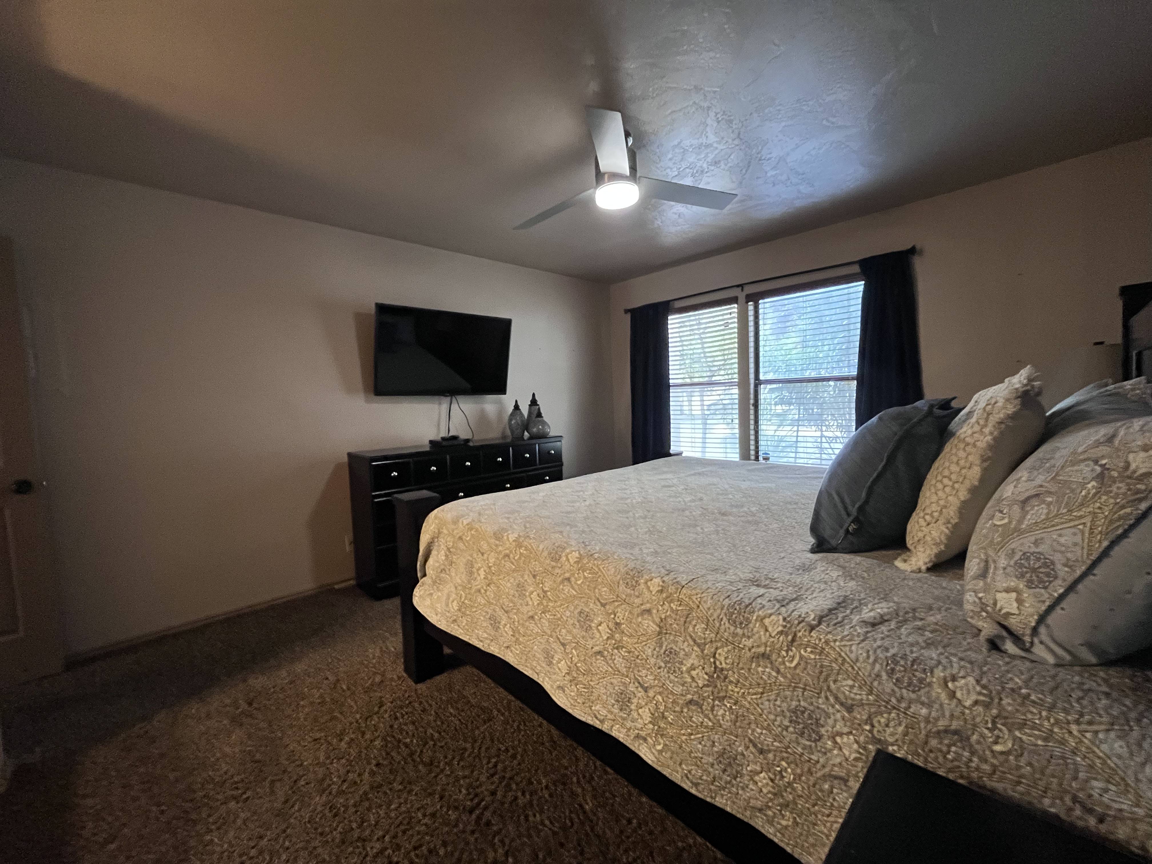 Bedroom featuring dark carpet and a ceiling fan