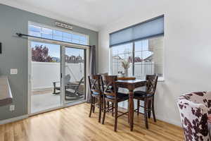 Dining area with light wood-style floors and ornamental molding