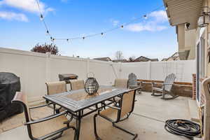 Fenced backyard featuring a patio, outdoor dining space, and area for grilling