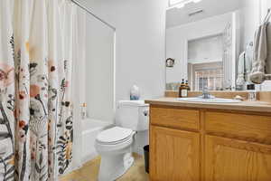 Full bath featuring vanity, shower / tub combo, and light tile patterned floors