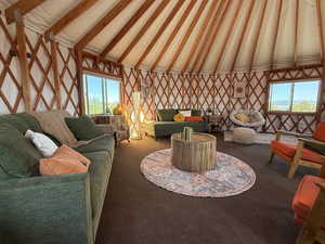 Living room featuring vaulted ceiling with beams, carpet, and healthy amount of natural light