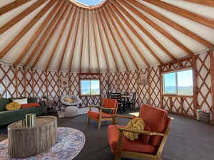 Carpeted living room with vaulted ceiling with beams