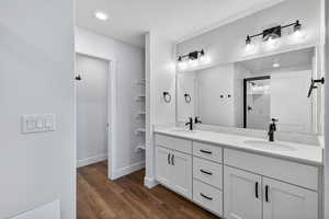 Bathroom with double vanity, a shower stall, dark wood-type flooring, a textured ceiling, and recessed lighting