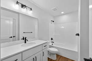 Bathroom featuring vanity, dark wood finished floors, and bathtub / shower combination