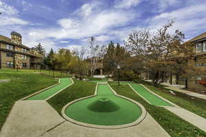 View of community featuring a putting area and lawn