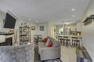 Living area with light wood-type flooring, recessed lighting, and a fireplace