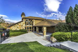 Rear view of property featuring a chimney, stone siding, a mountain view, and a shingled roof