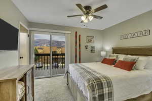 Bedroom with a mountain view, brand new carpet, access to outside, and ceiling fan