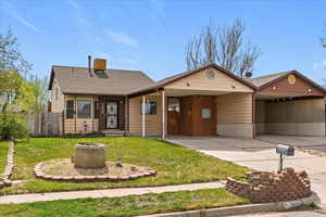 View of front of home with an attached carport, a shingled roof, and driveway