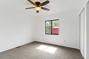 Unfurnished bedroom with a ceiling fan, carpet flooring, and a closet