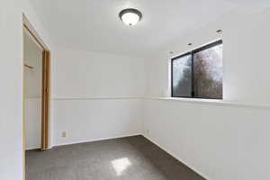 Unfurnished bedroom with carpet floors and a textured ceiling