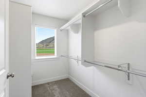 Walk in closet featuring dark carpet