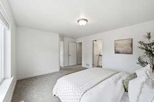 Bedroom featuring light carpet and ensuite bath