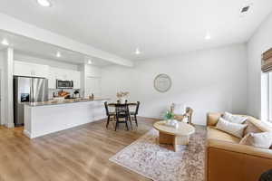 Living area featuring light wood-style flooring and recessed lighting